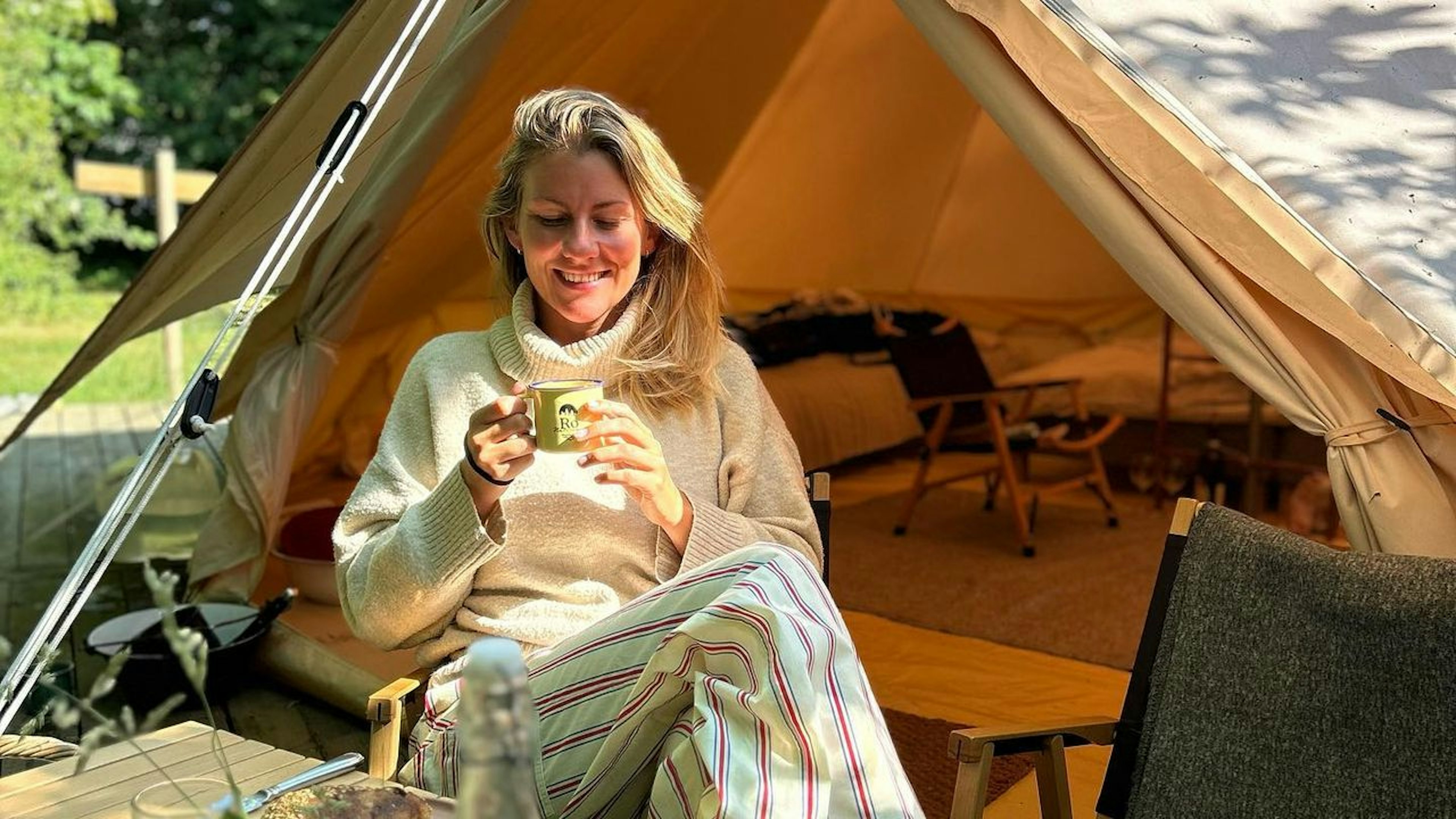 mette somer sidder ude foran hendes telt med en kop kaffe i hånden